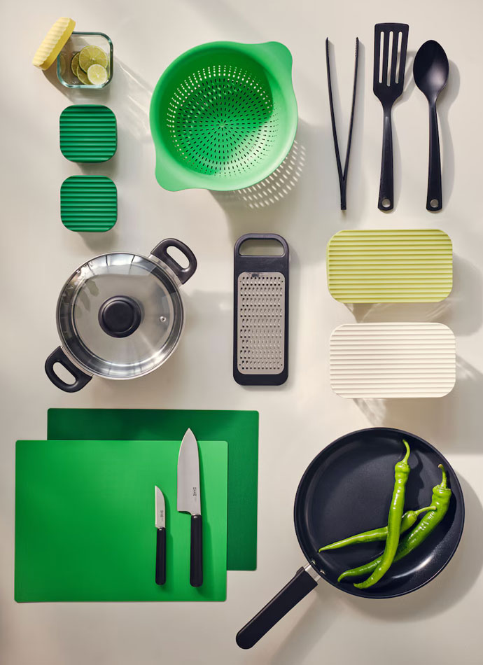 Top view of kitchen accessories such as pans, pots, pans, saucepans and kitchen utensils in green and metallic color.