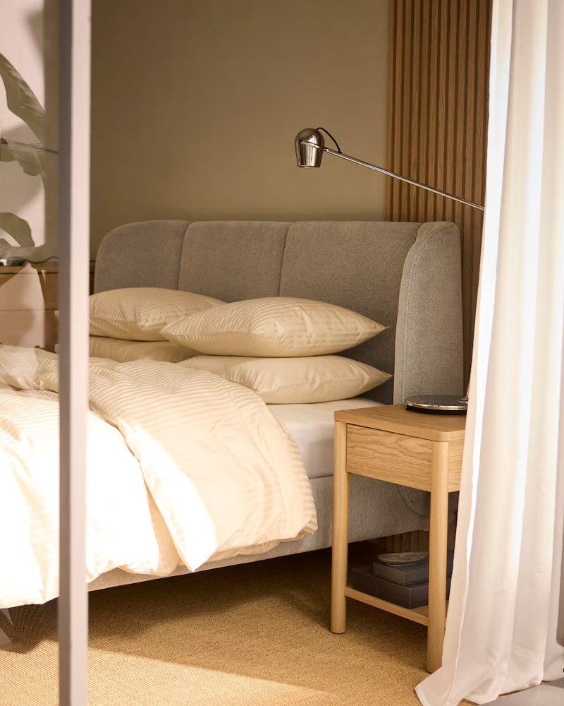 Elegant bedroom with TUFJORD upholstered bed, NATTJASMIN bedding, TONSTAD nightstand and DYTÅG sheer curtains.