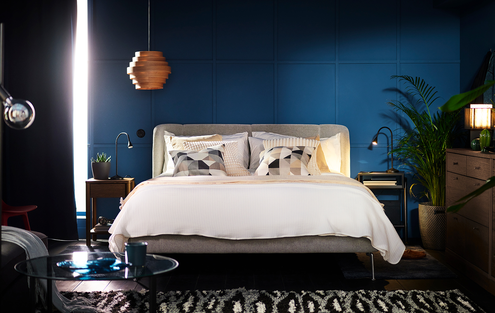 TUFJORD upholstered bed in a blue bedroom covered with BREDVECKLARE bed linen.