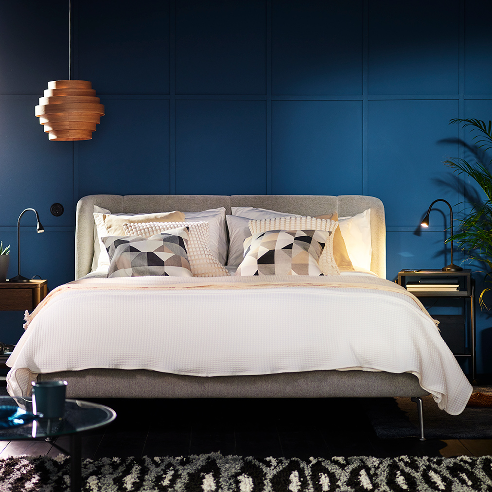 TUFJORD upholstered bed in a blue bedroom covered with BREDVECKLARE bed linen.