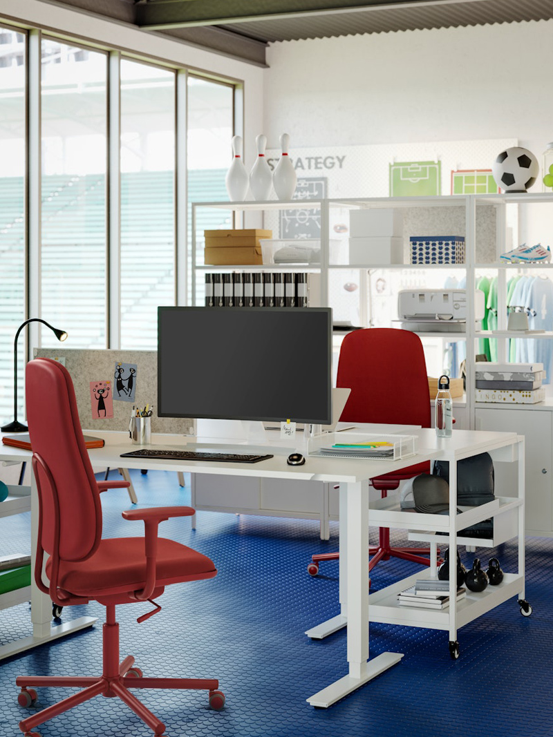 Red work chair in front of a white desk in an office in a modern and creative environment.