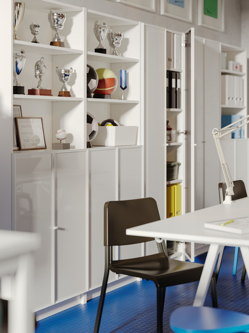 Cabinets with shelves full of sports trophies, there is a black chair in front of a creative and modern desk.