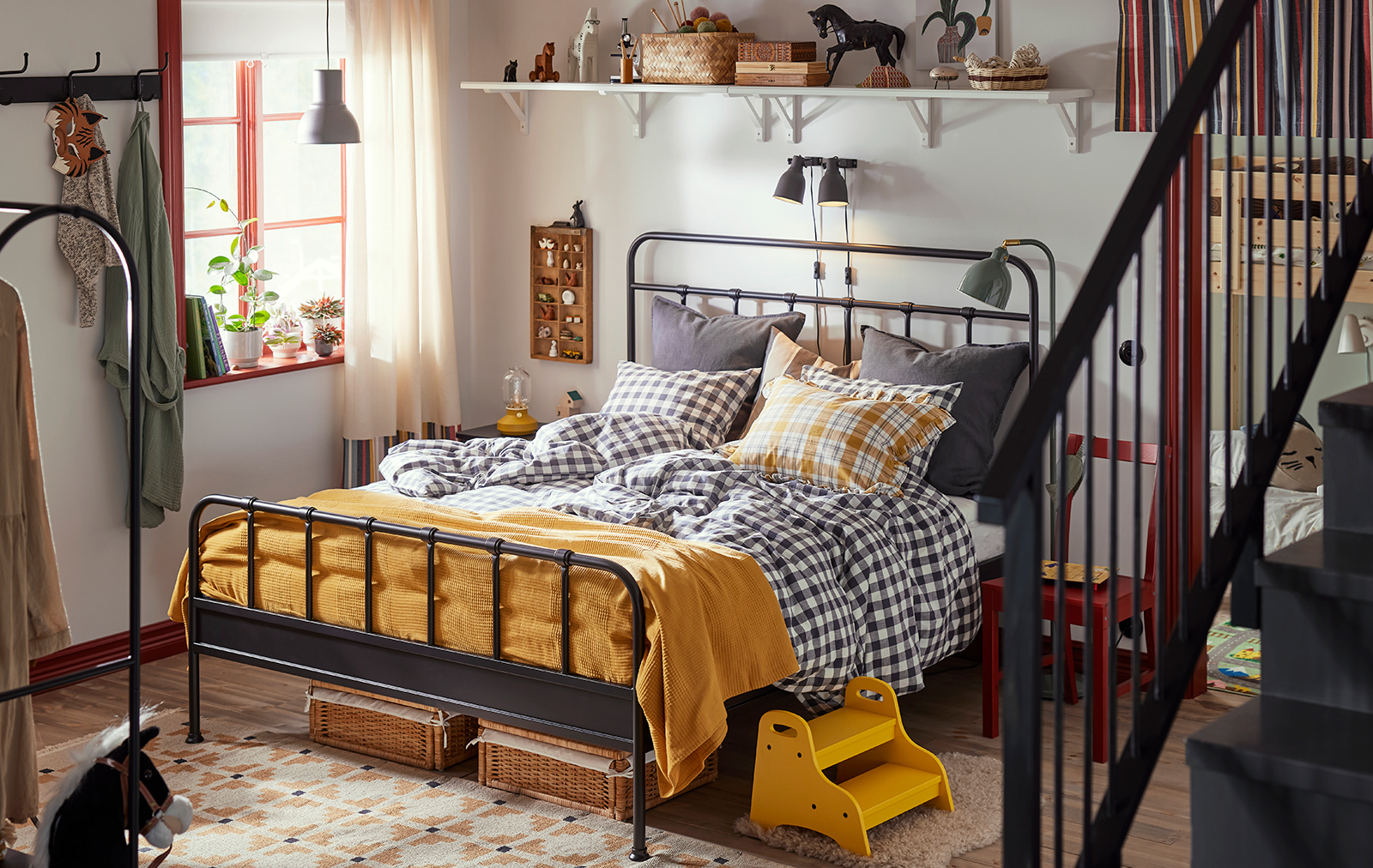 Warm room with STJÄRNÖ bed and plaid quilts.