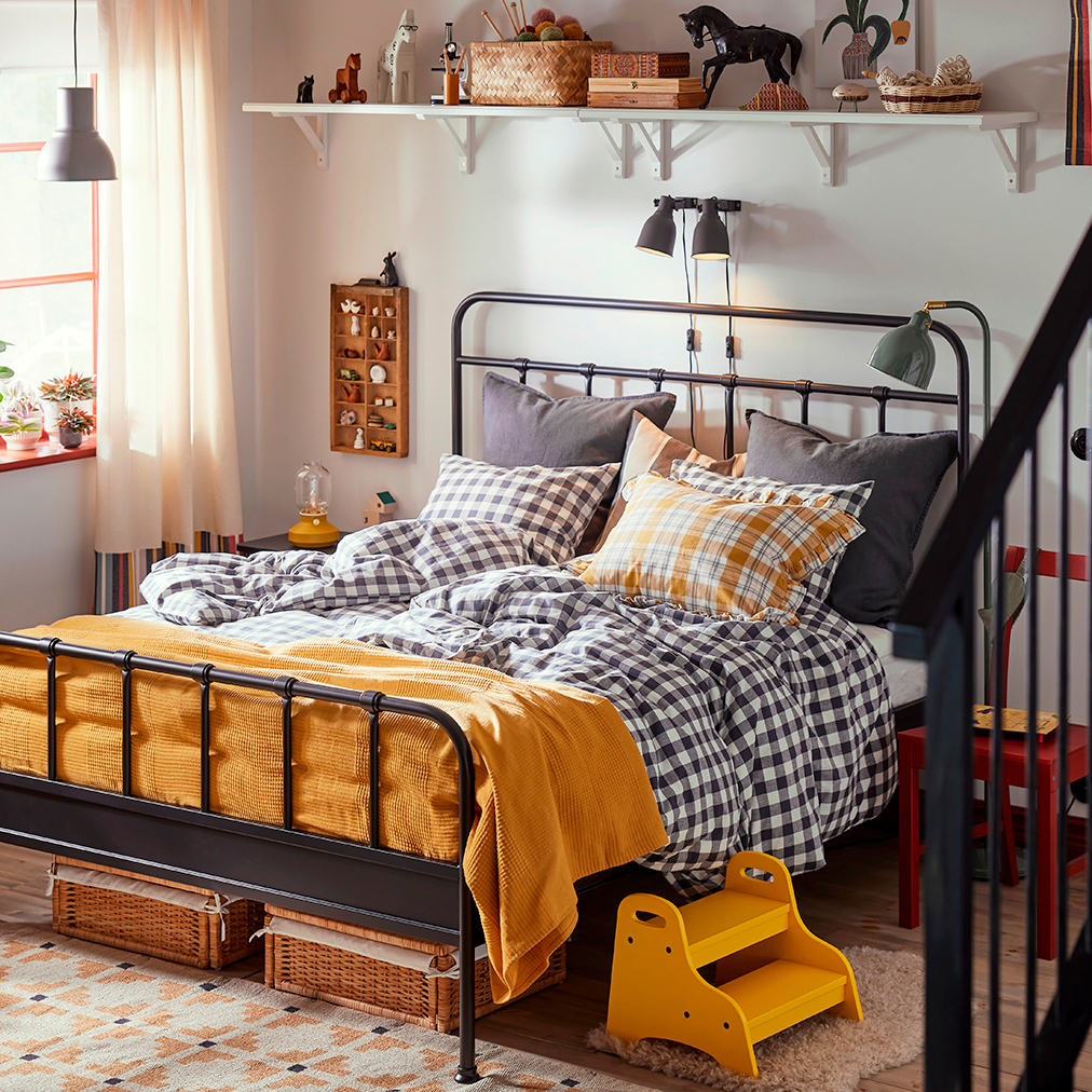 Warm room with STJÄRNÖ bed and plaid quilts.