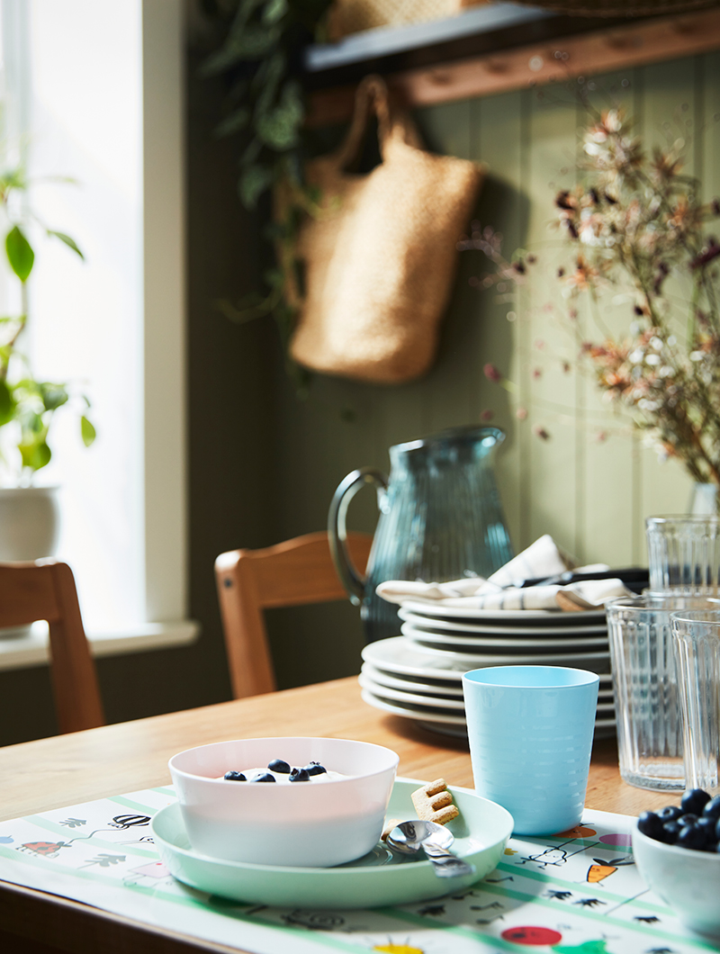 Children's tableware, plastic, in the bowl are served blueberries with yougurt, on a vintage table.