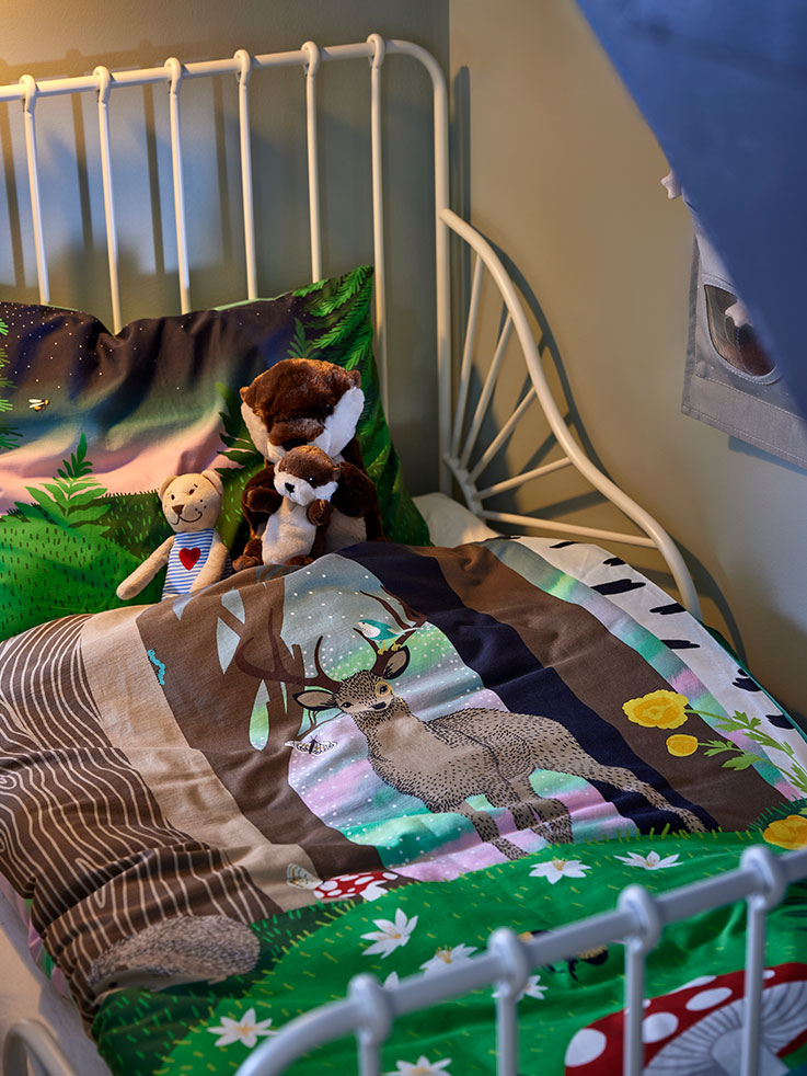  Children's room with a MINNEN extendable bed featuring a SKOGSDUVA duvet and soft toy, along with a FABLER BJÖRN stuffed animal.