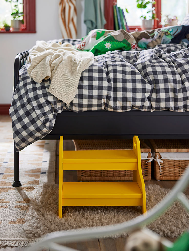  Bed with an EKTANDVINGE duvet on top and a TROGEN stool.
