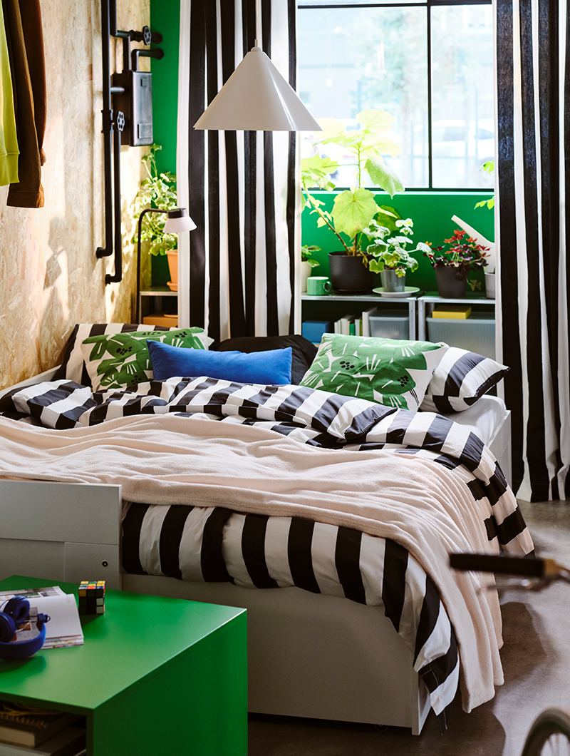  A SLÅNHÖSTMAL duvet on a BRIMNES daybed next to a GARGANAS coffee table.