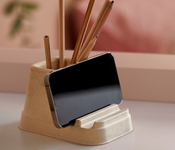  Beige stand with wooden pencils and mobile phone. Tidy, minimalist desk ambiance.