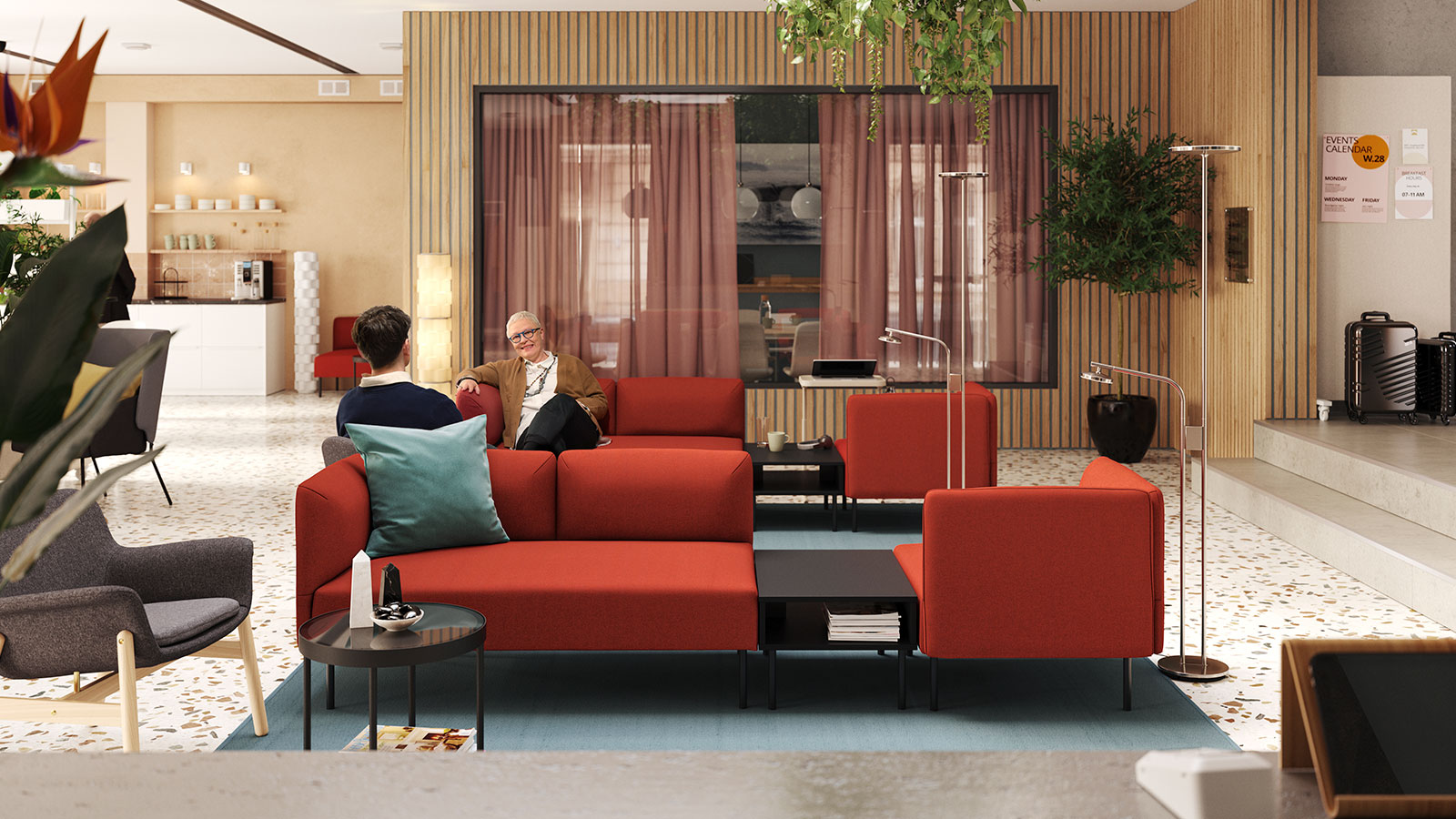 Modern lounge with red sofas, people chatting, and cozy decor.