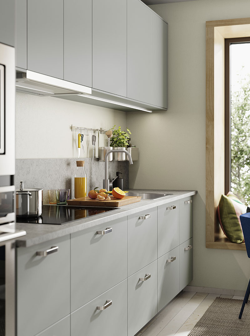 Modern kitchen with gray cabinets, light countertop, and green plants. Bright and cozy atmosphere.