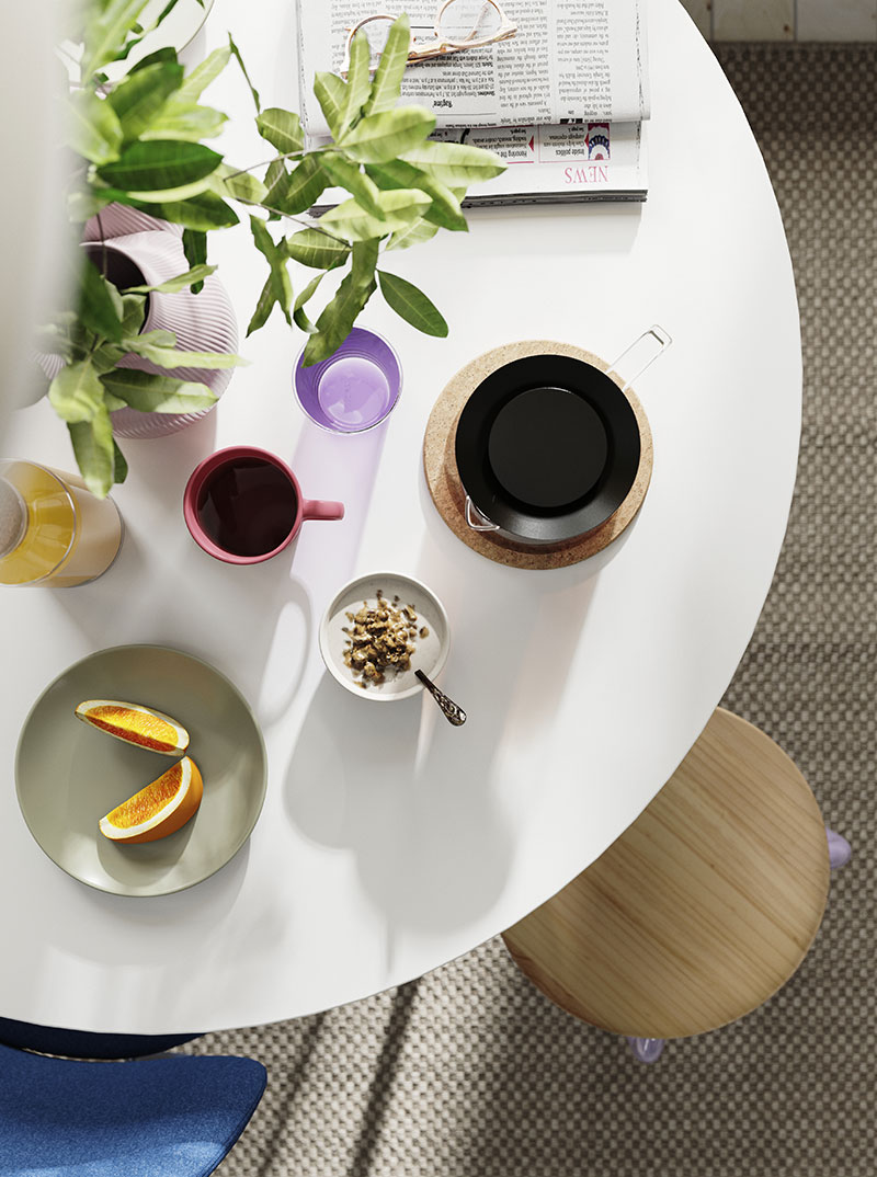 White round table with breakfast, juice, coffee, and fruit plate. Morning and fresh atmosphere.