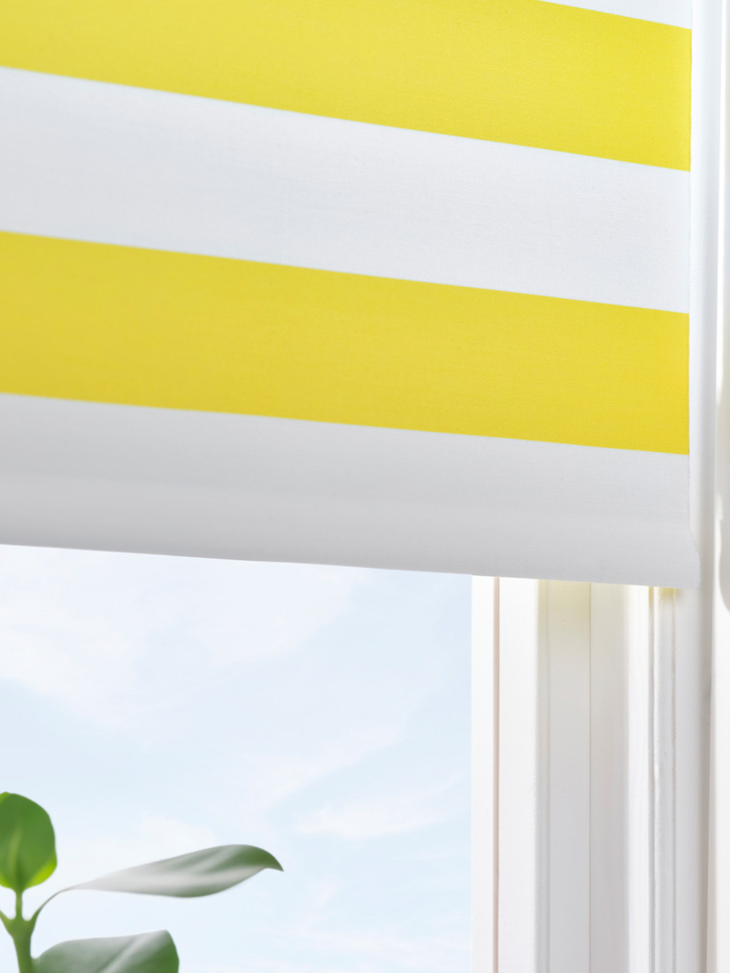 Yellow and white striped blinds on a window, creating a bright and cozy environment.