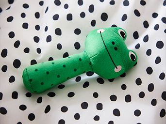 Baby rattle shaped like a frog plush toy.
