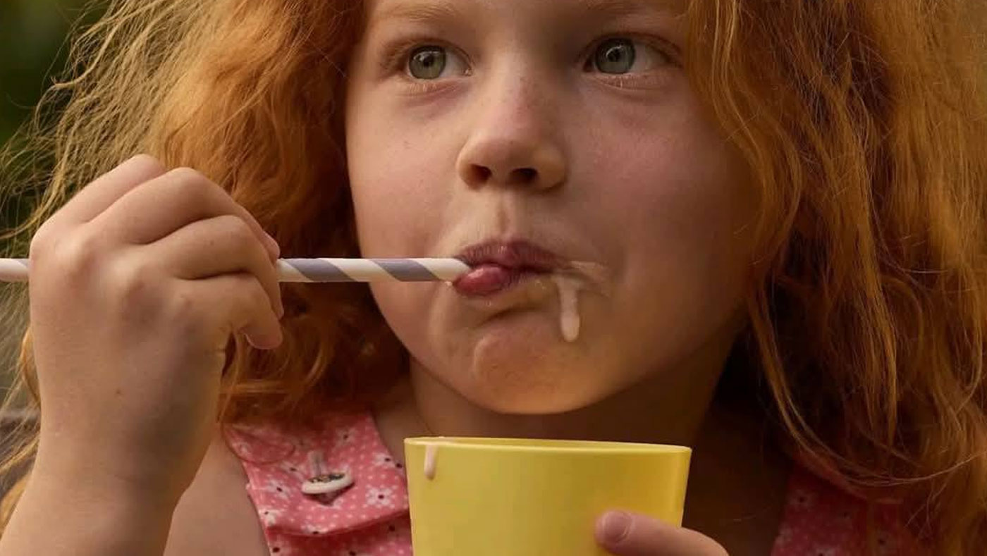 red-haired girl eating in a yellow cup