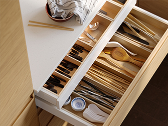 Open kitchen drawer with UTRUSTA cutlery organizer, sorting knives, forks, spoons, and chopsticks. Keep your utensils always in order.