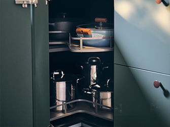 Interior of a dark kitchen corner cabinet with pull-out shelves, organizing pots and pans. Smart solutions to optimize every corner.