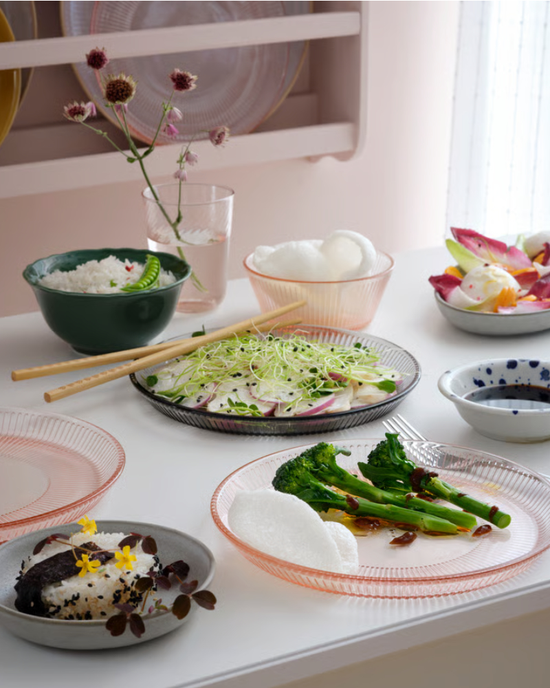 A pink HAVSGÄDDA side plate is elegantly displayed with various dishes, including salad, rice, and vegetables.