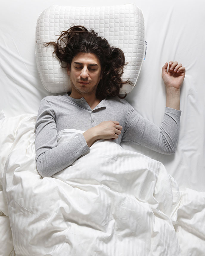 Person lying face up, on white comforte