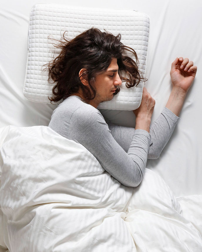 Person lying on side, on white comforte