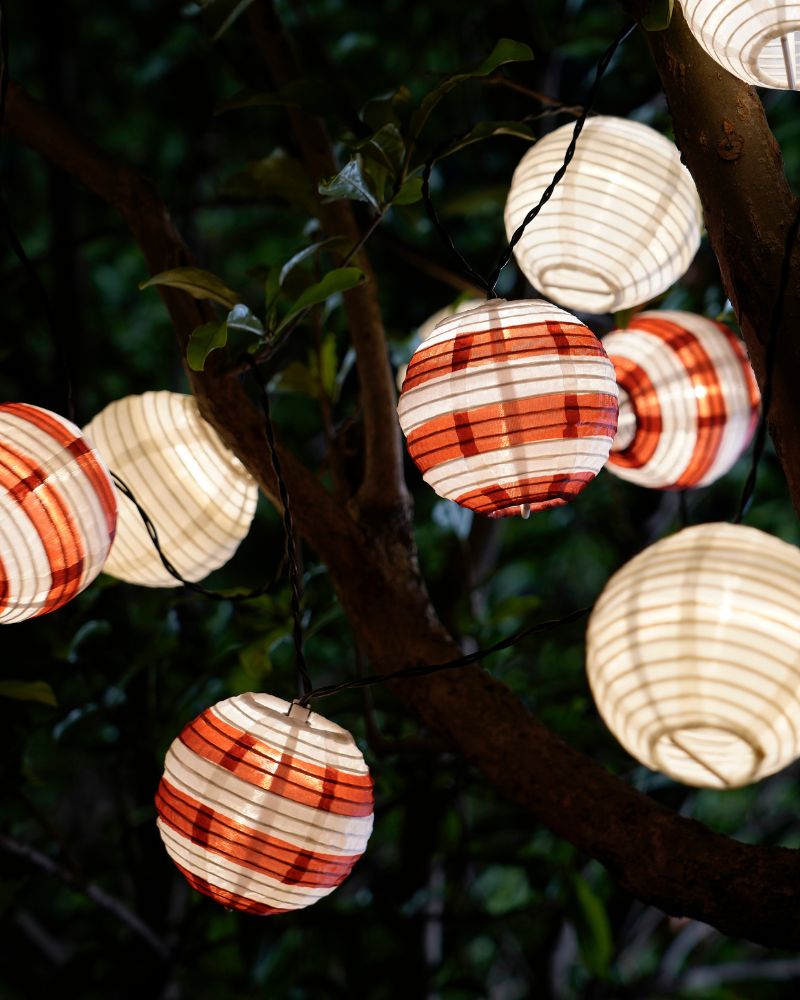 Cozy outdoor garden with IKEA SOLVINDEN LED light chain, 12 lantern lights creating a warm and festive glow.