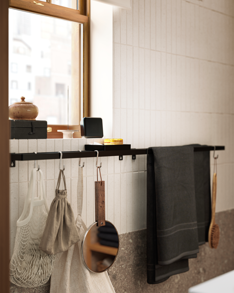 Black towel rack with black towel and mesh bag. Elegant bathroom detail