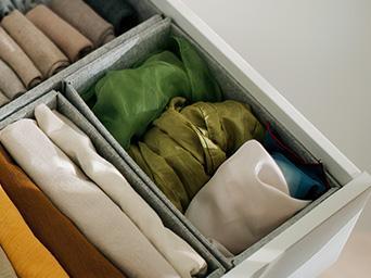 Drawer with neatly folded clothes in compartments