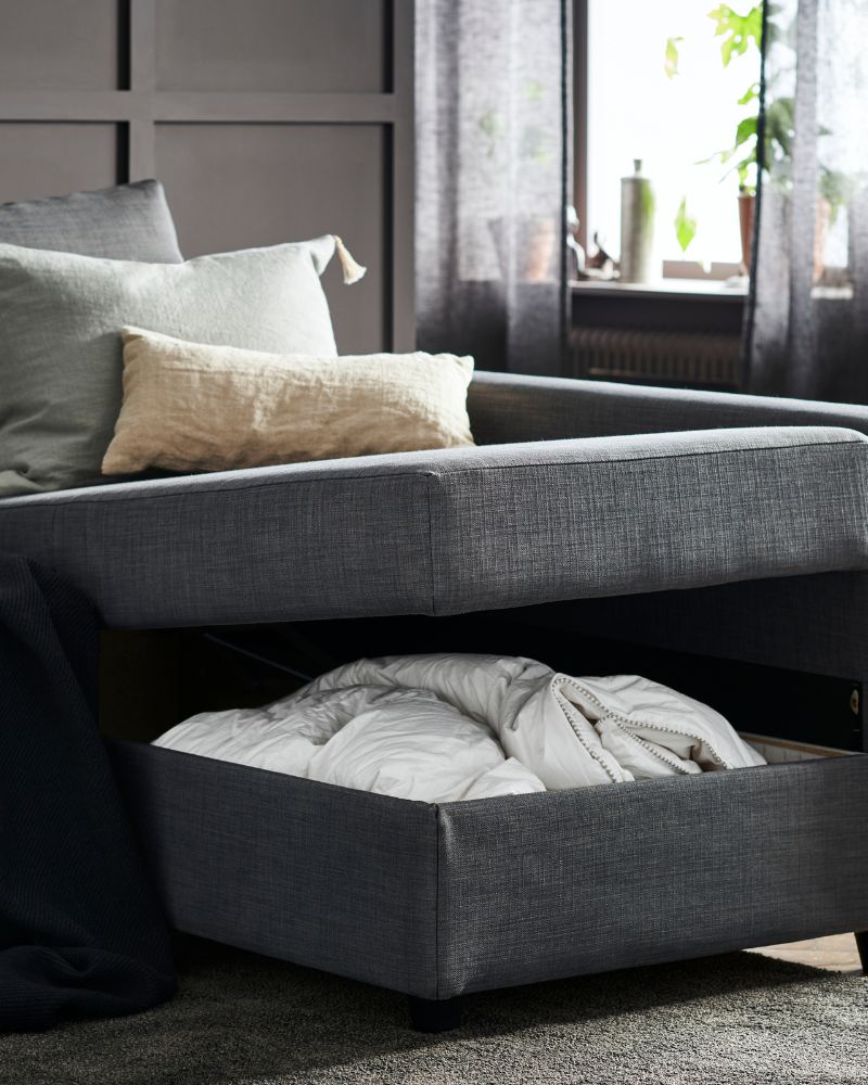 Practical living room with FRIHETEN sofa bed, STOENSE rug, SÄFFEROT duvet and LENDA curtains.