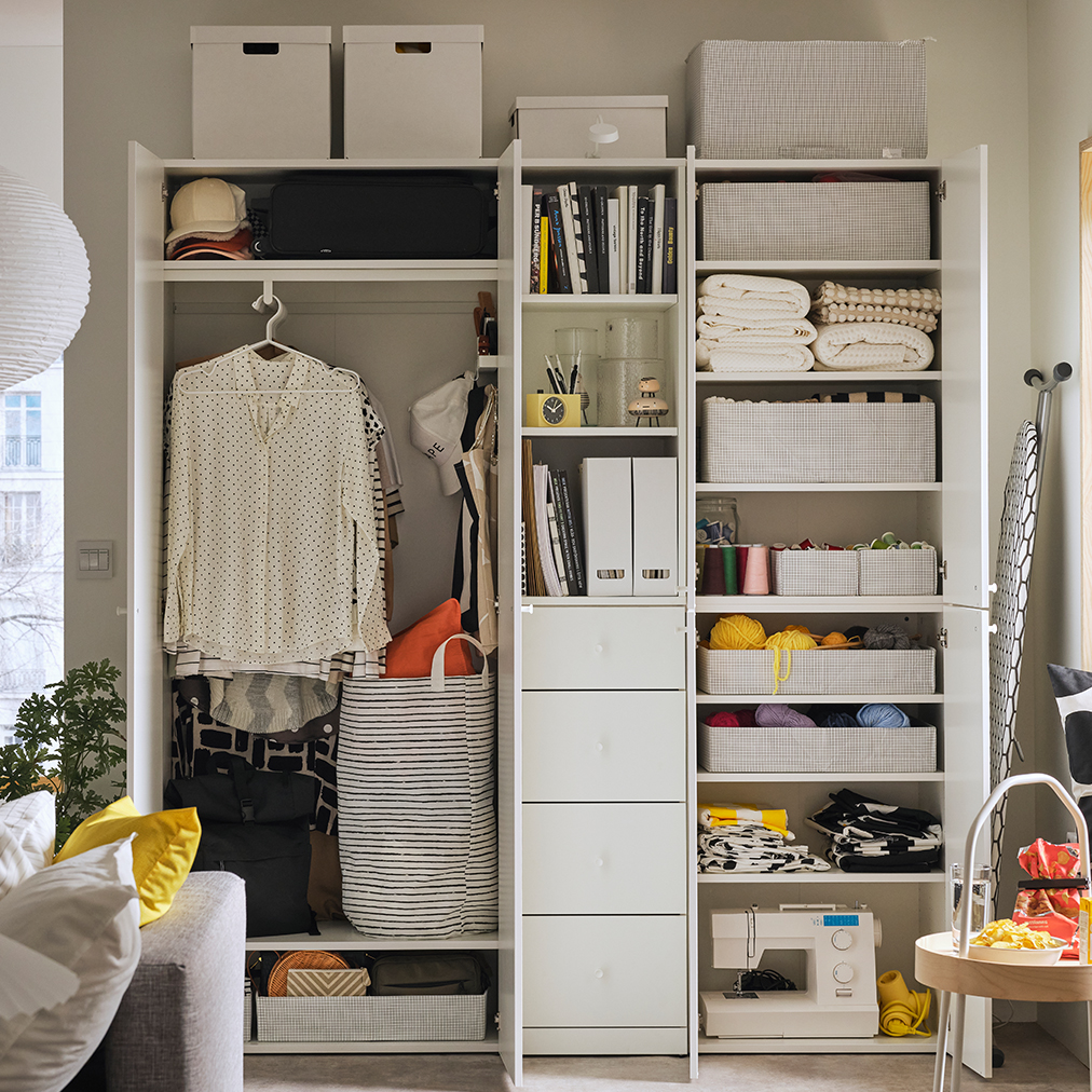 Inside a LASTARE wardrobe combination with STUK boxes on shelves and wire baskets storing neatly folded textiles.