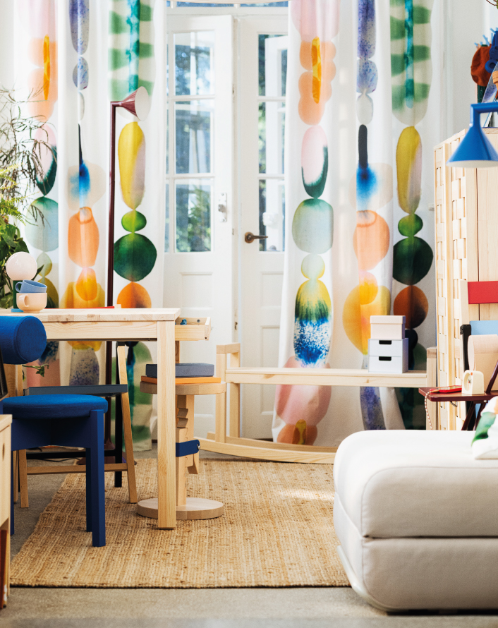 Bright living room with colorful curtains and light wood furniture.