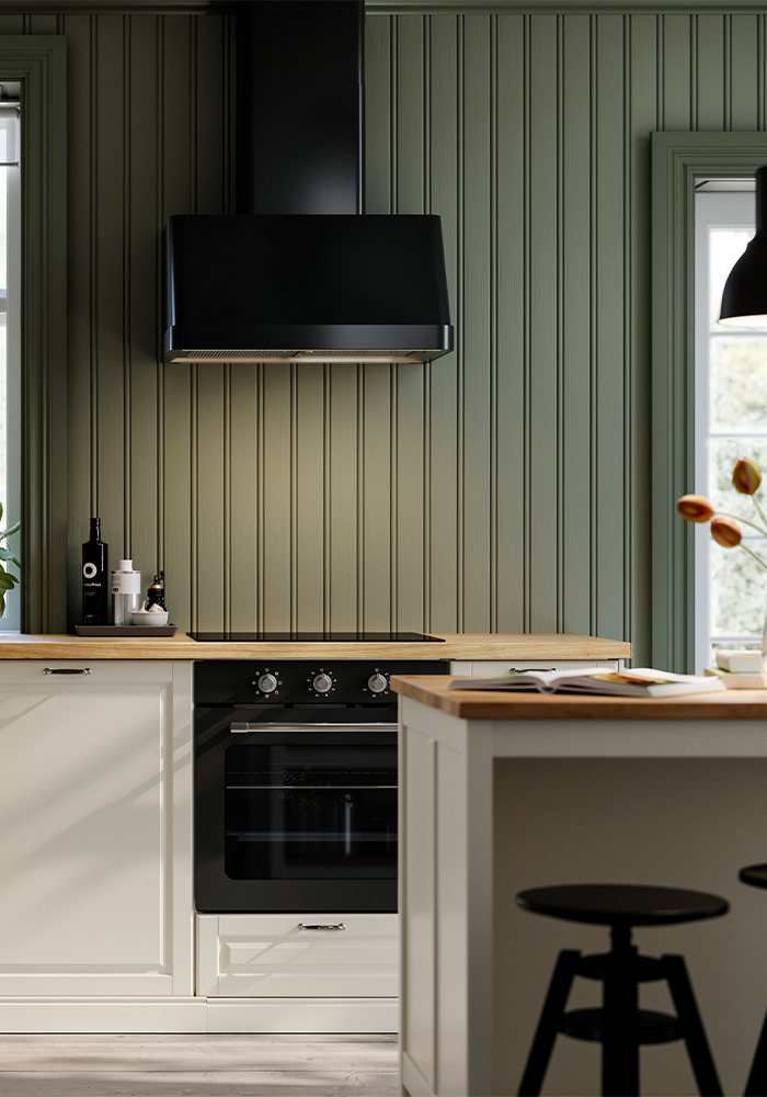 Modern kitchen with a black oven, range hood, and wooden countertop.