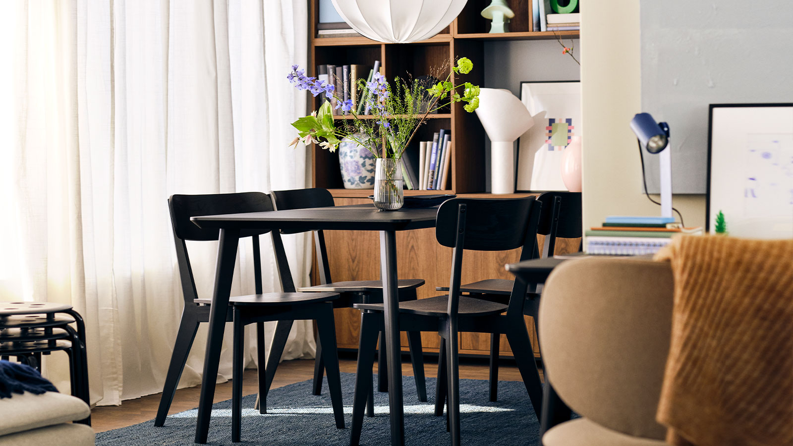 A modern, dark, and bright dining room in a Scandinavian or minimalist style residential interior.