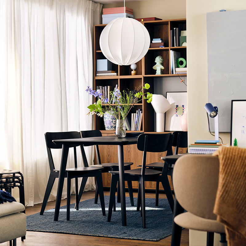 A modern, dark, and bright dining room in a Scandinavian or minimalist style residential interior.