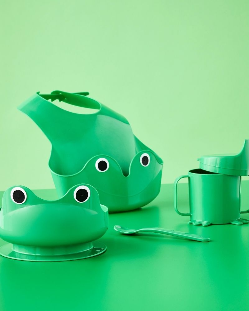 Bright green frog-themed four-piece MATA baby tableware set with bib, bowl, sippy cup and spoon.
