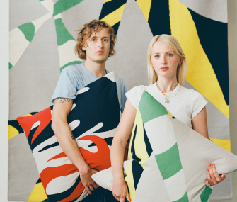 People posing with artistic designer cushions.