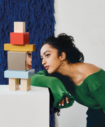 Person observing a colorful geometric sculpture.