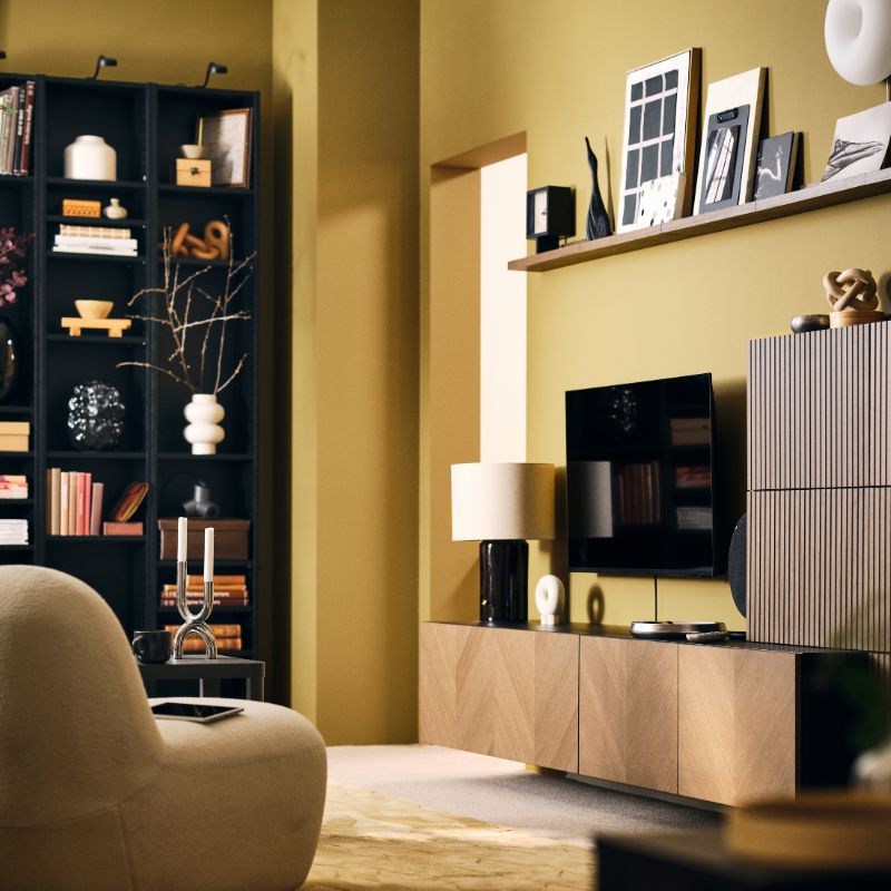 A neat, light living room with a BESTÅ storage combination with wood-veneer fronts, bookshleves and easy chair.