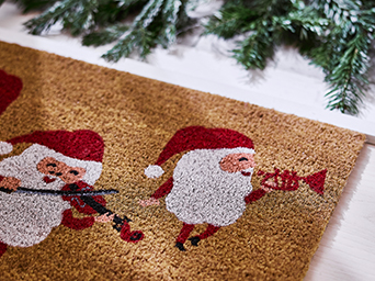 Wrapped gifts featuring floral and checkered patterns in red, black and white, placed beneath a Christmas tree with warm lights and festive ornaments.