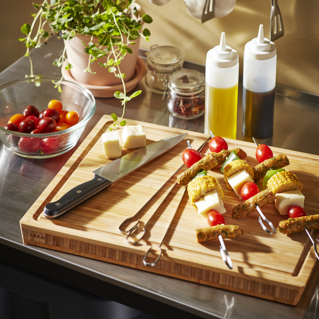 Una tabla de cortar de bambú con un cuchillo, queso y brochetas de verduras.