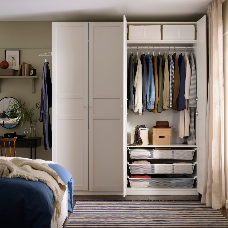 White open wardrobe with hanging clothes and organized drawers in a modern bedroom