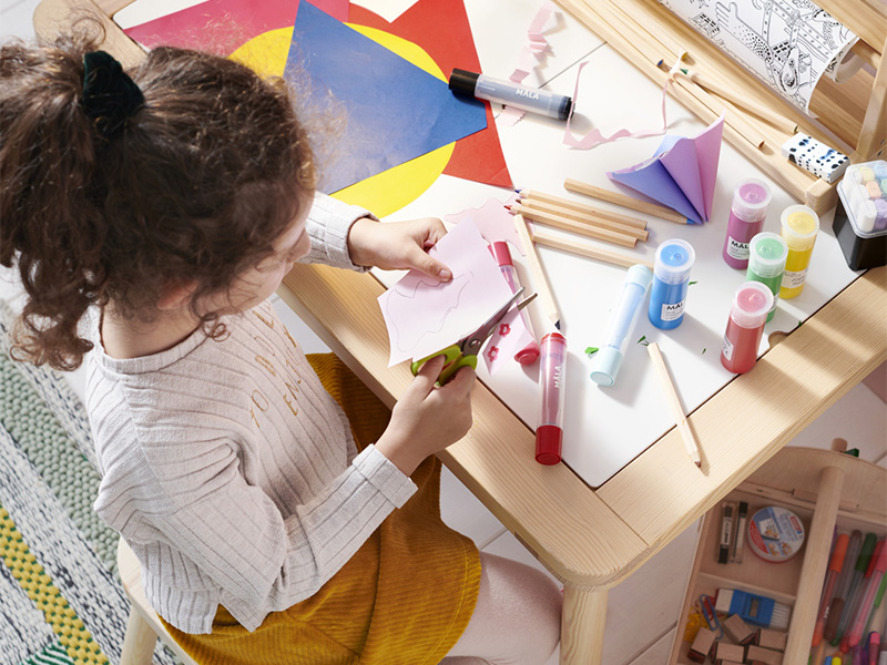 Person doing a crafts activity at a children's table.