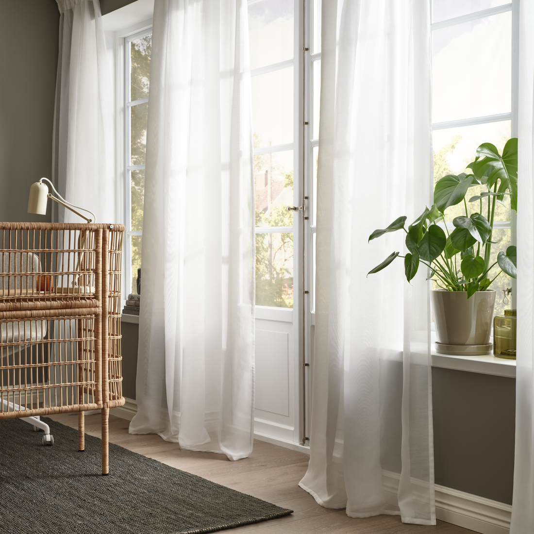 Cortinas claras junto a una ventana con plantas.
