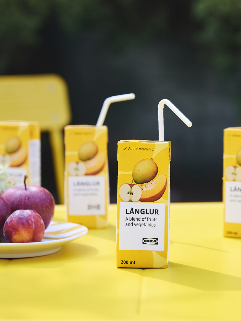Caja de bebida de frutas sobre una mesa amarilla.