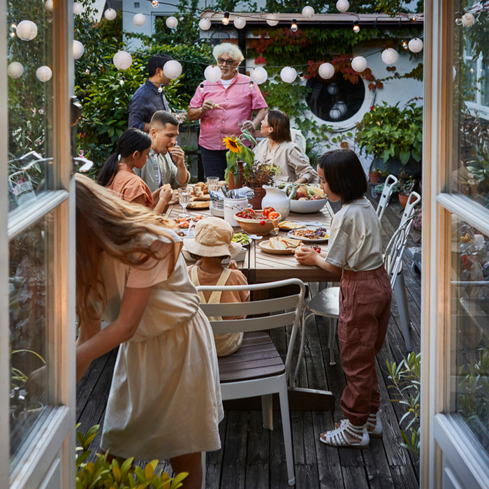 Personas reunidas alrededor de una mesa en un jardín.
