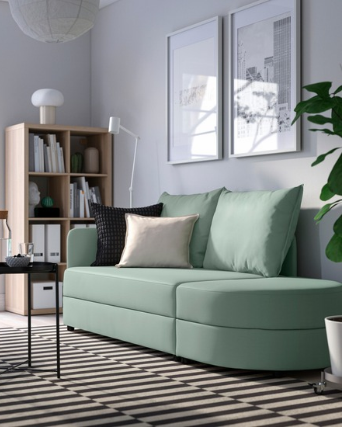 Sofá de color verde claro en un salón moderno con luz natural.