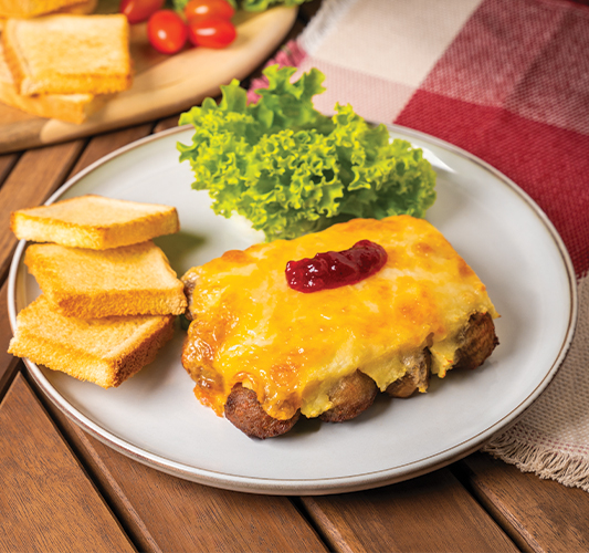 Plate of baked meatballs with melted cheese, jam, toast, and fresh lettuce.