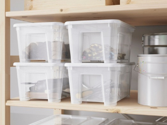 Cajas de plástico transparente organizadas en estantes de madera.