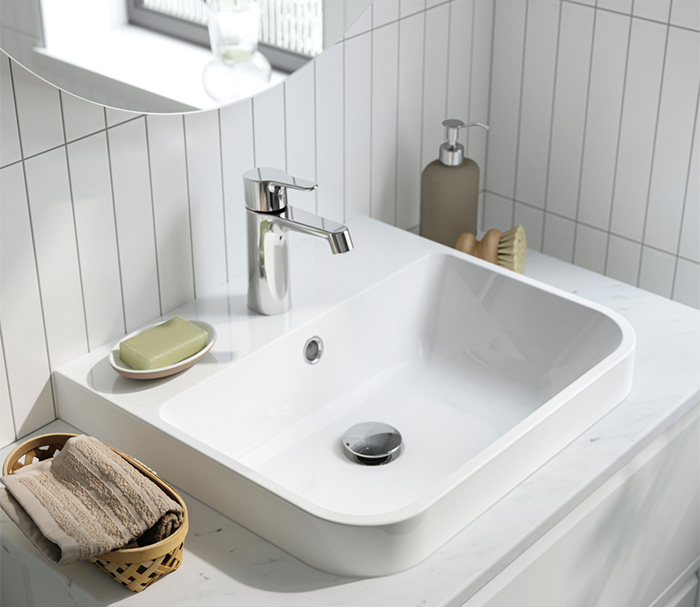 Lavabo blanco moderno con grifo cromado.